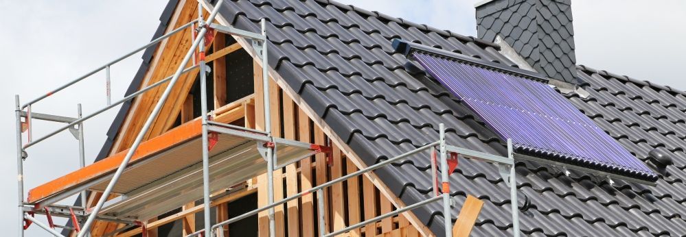 Dach eines Neubaus mit Gerüst und Solarthermieanlage